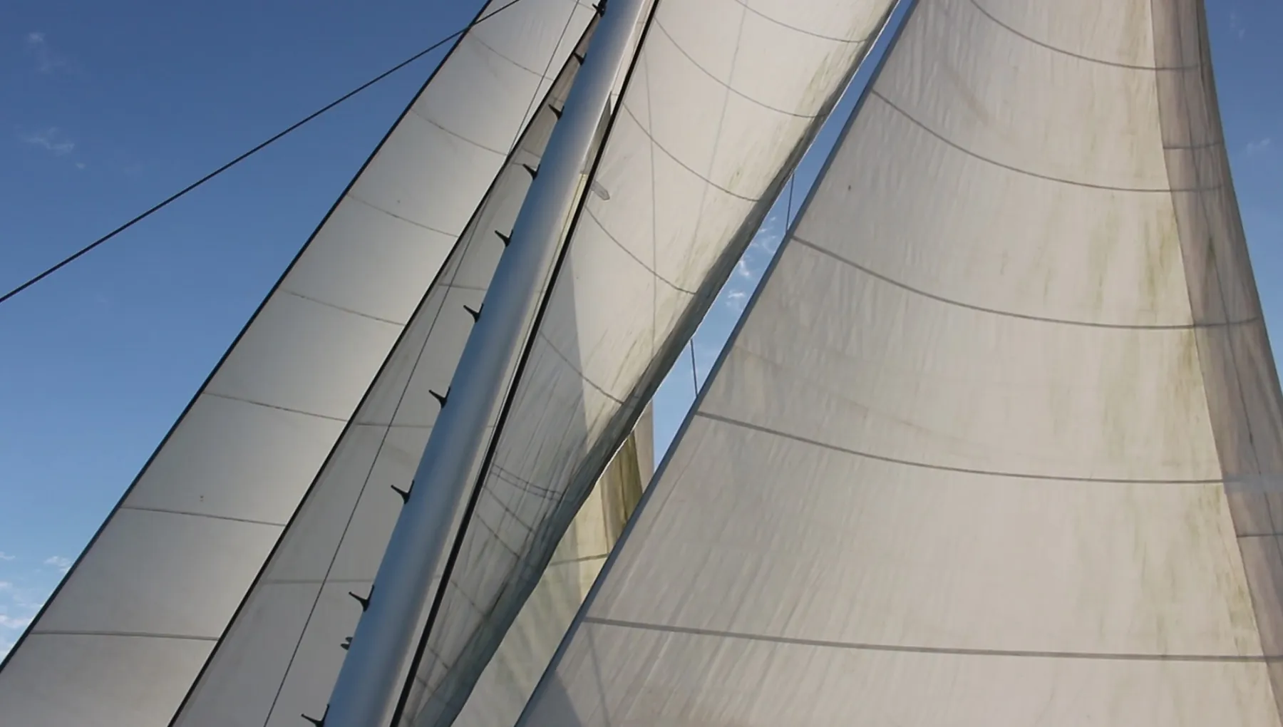 Full sails set against blue sky on a Gold Coast sailing voyage aboard superyacht VOYŌ